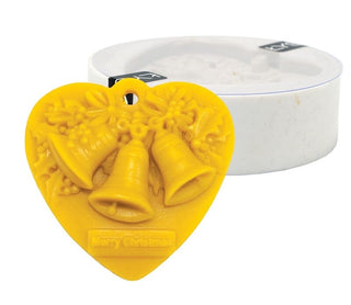 Lyson silicone candle mould shaped as a pendant with three bells and "Merry Christmas" made from yellow beeswax with a mould in the background. 