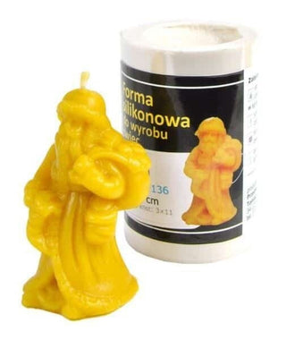 Yellow beeswax santa clause candle next to a silicone candle mould to make it against a white background. 